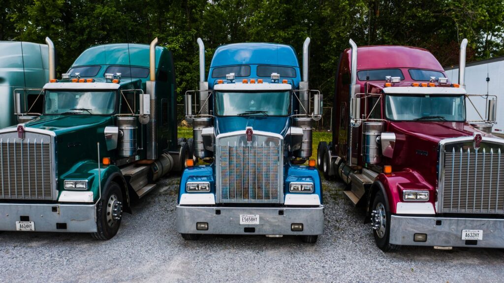 Three semi truck tractors parked in a row